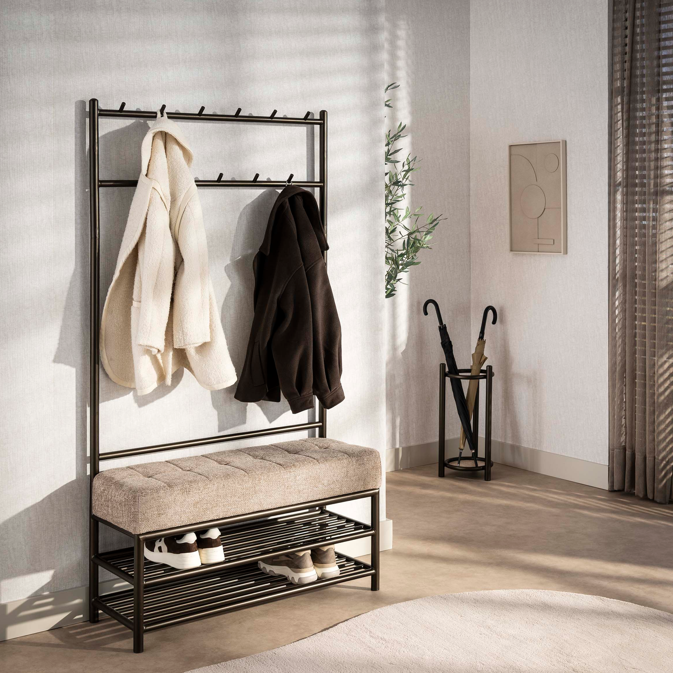 Wall-mounted coat rack with hooks and a cushioned bench below, featuring two coats and shoes on a neutral background.